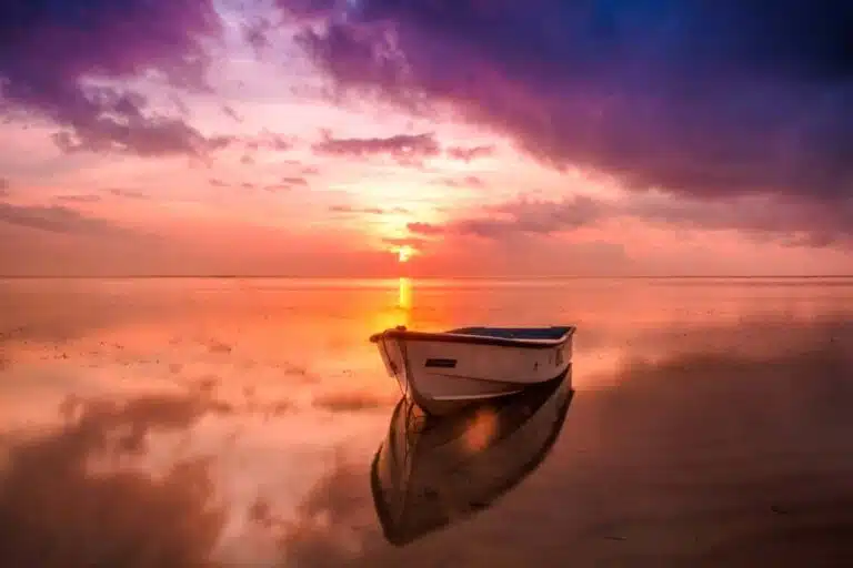 Wooden boat floating peacefully in calm water at sunset with purple and golden sky, representing faith poetry about divine timing and missed opportunities