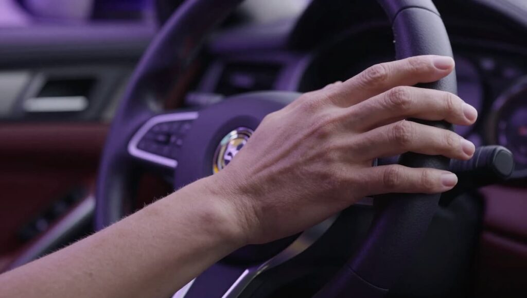 Peaceful hands on steering wheel representing slowing down and finding calm in chaotic world