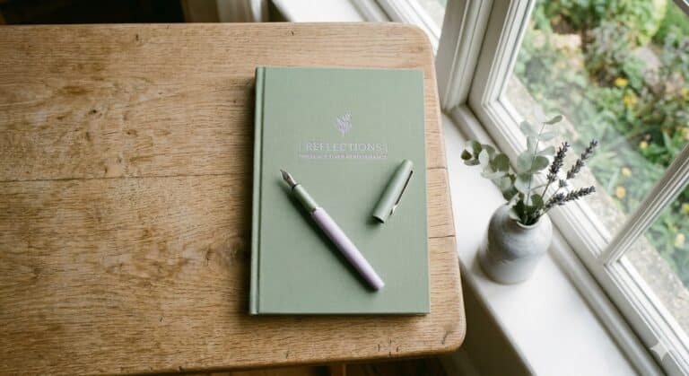 Closed journal and pen representing Christina Eder's choice to step away from digital blogging for in-person soul care ministry